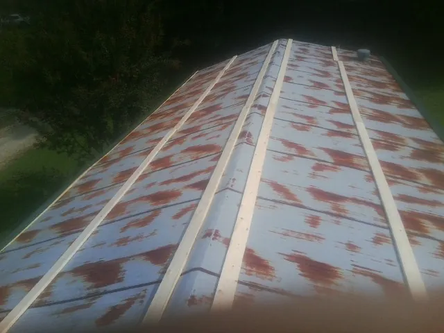 Rusted metal roof panels with new wood purlins before replacement — Storm Damage Roof Repair in Shutesbury by Roofing Brothers