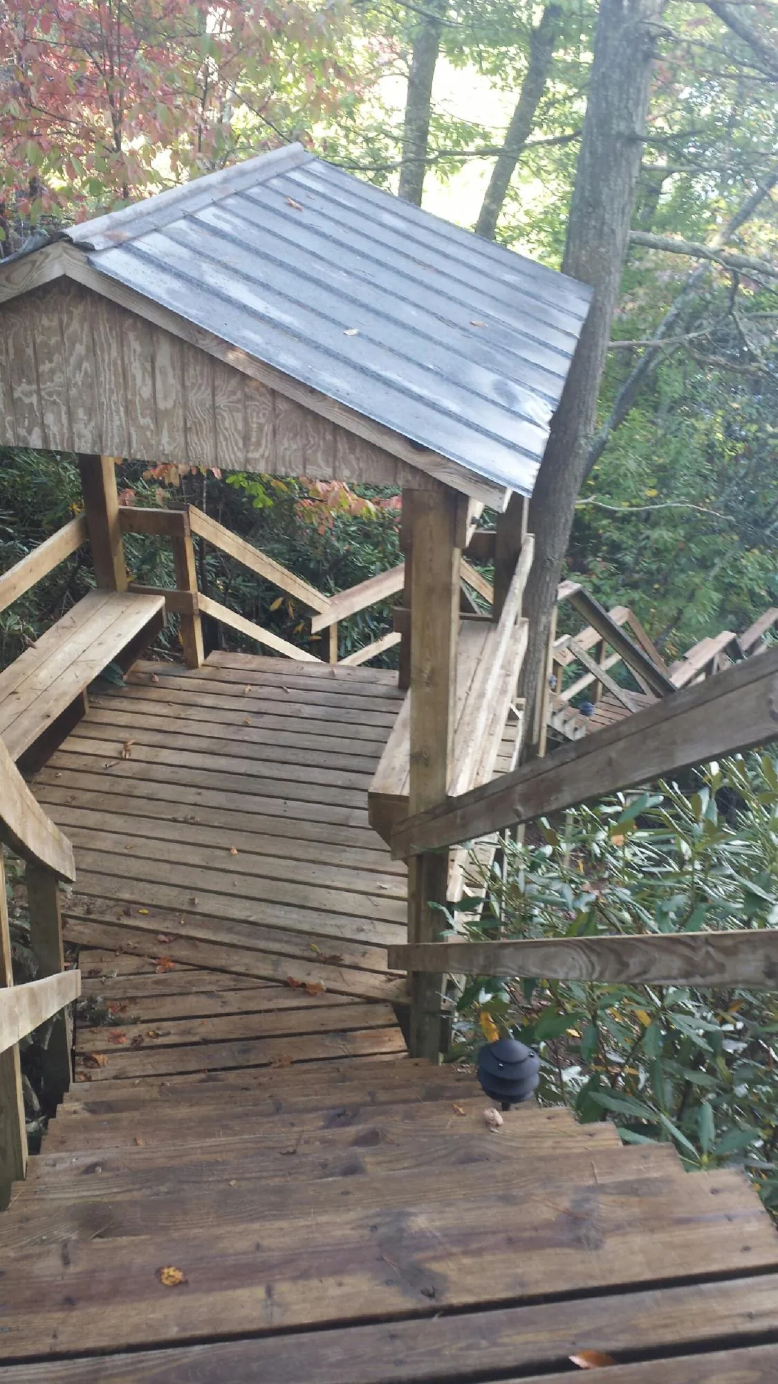 Metal roofed shelter over wooden steps on a wooded walkway — Skylight Repair & Installation work by our crew in Shutesbury