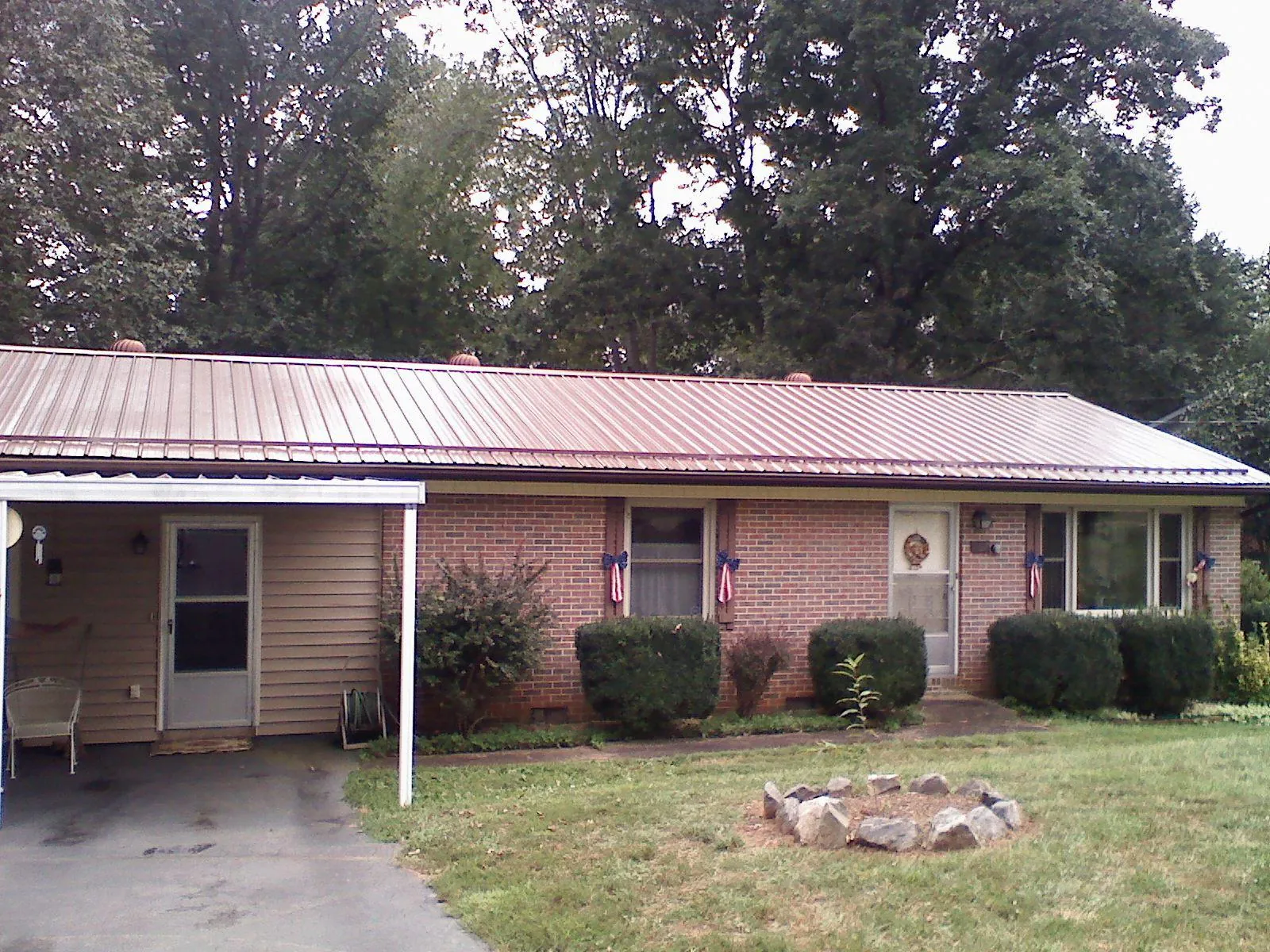 Bronze metal roof and carport on a brick ranch home — Roof Repair work by our crew in Shutesbury